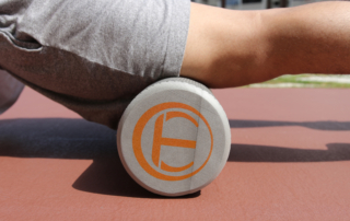 man foam rolling leg muscles