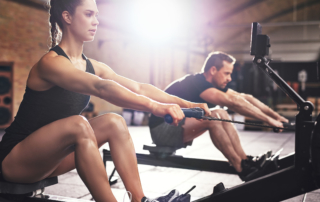 man and woman working out by rowing