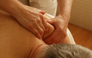 closeup of shirtless man receiving a massage due to chronic back pain