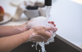 hands cupping soapy water while washing hands thoroughly