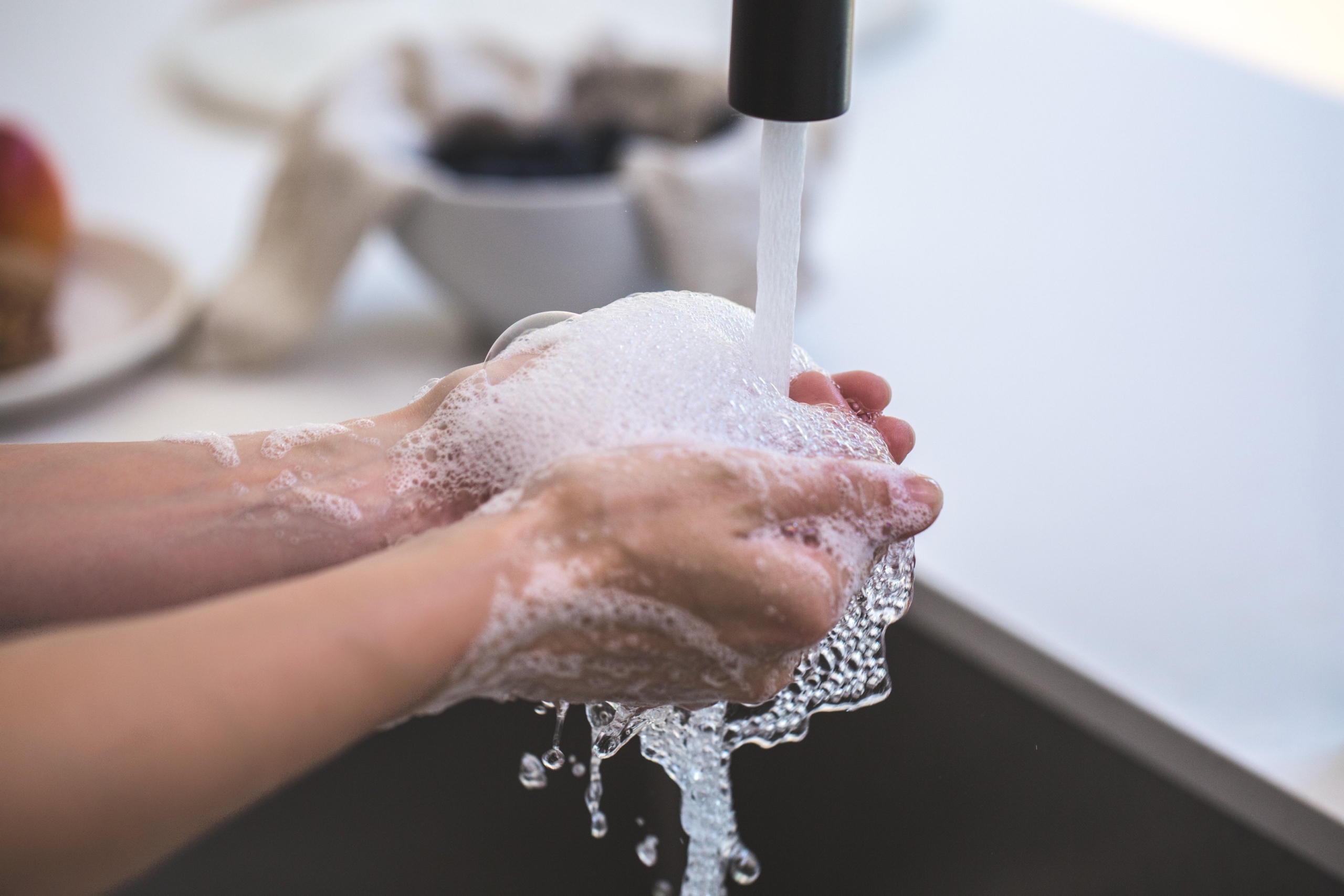 hands cupping soapy water while washing hands thoroughly