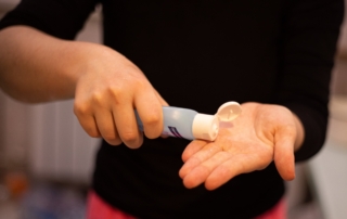 woman following safety regulations by using hand sanitizer