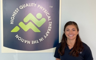Gina Martinez in front of a sign for Momentum Physical Therapy