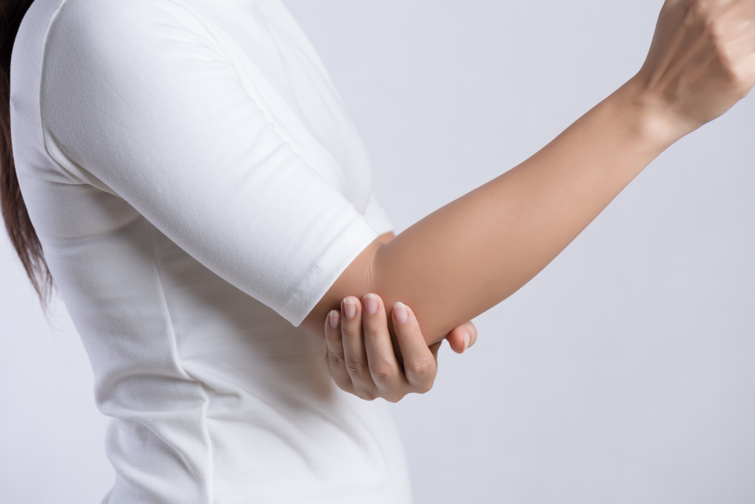 woman holding her elbow in pain