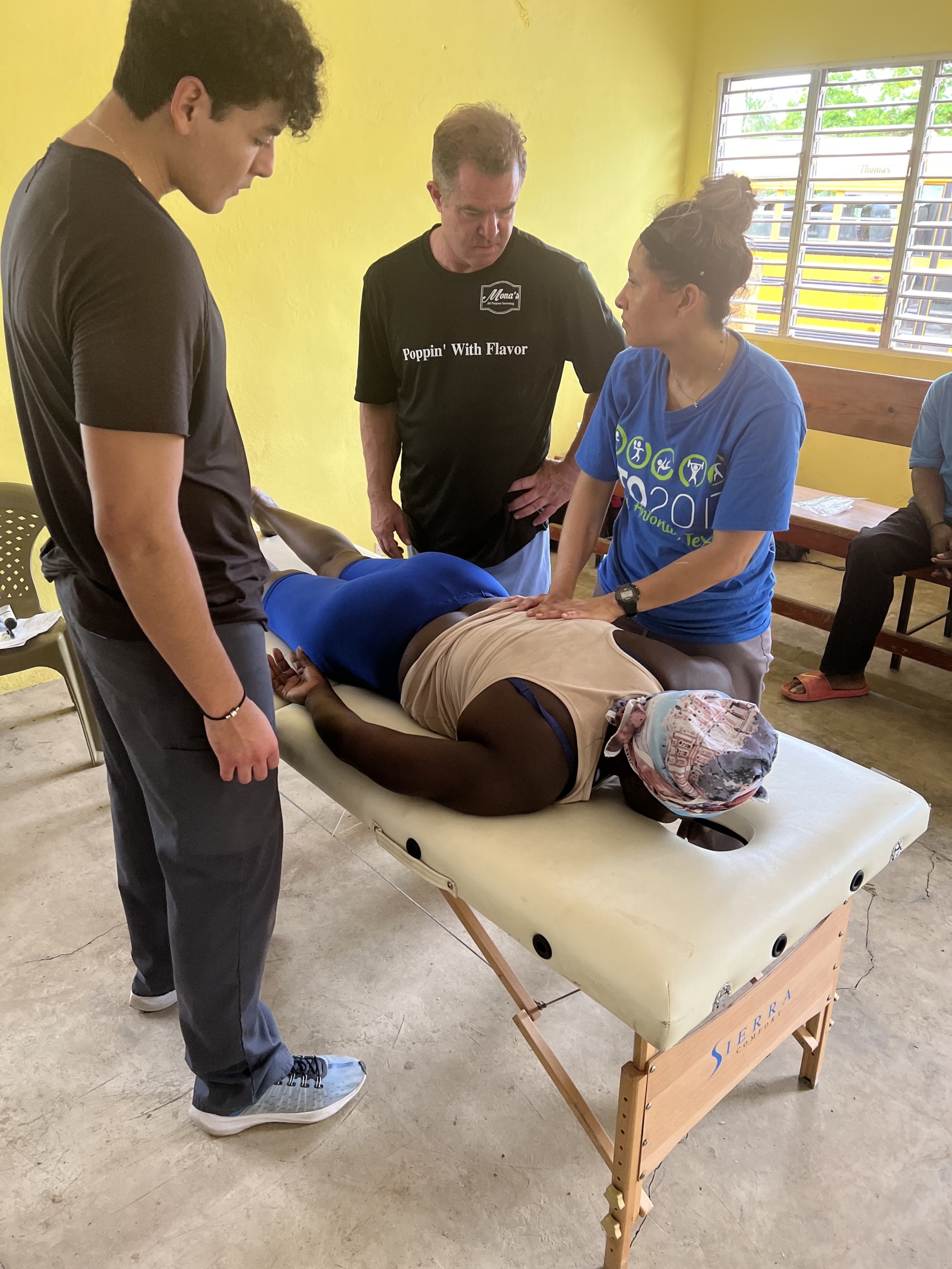 momentum staff members performing physical therapy on a patient laying on the table